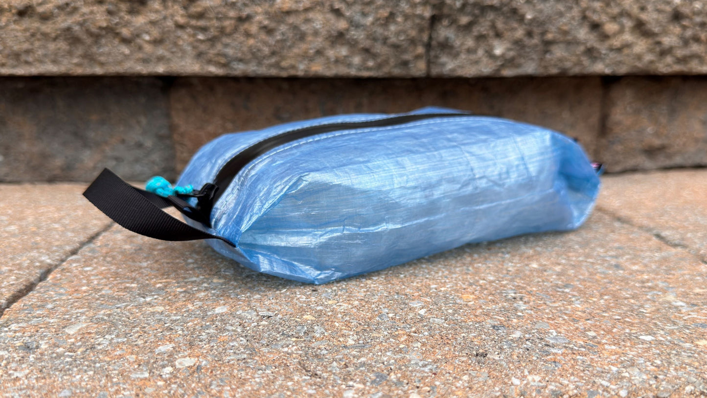 Blue plastic bag with a black zipper on a stone surface
